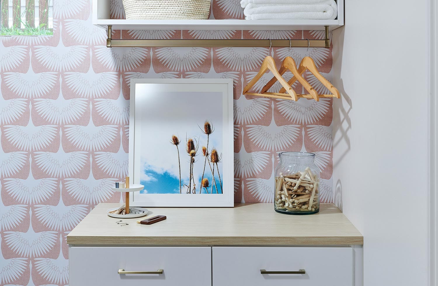 Small room design for laundry storage with tilt hampers designed by California Closets